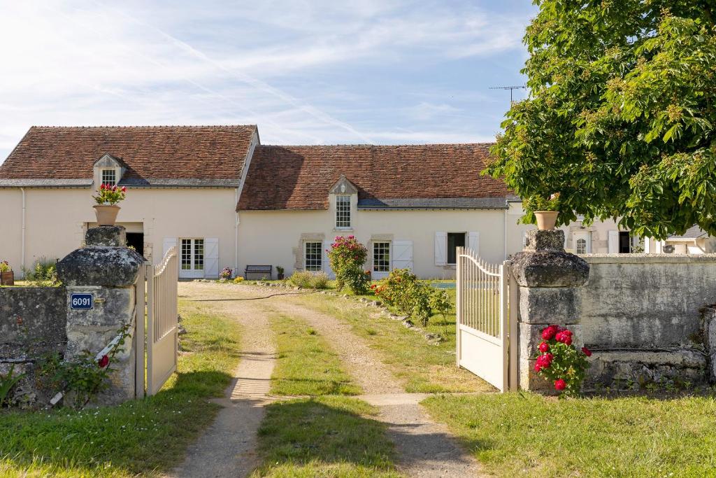a white house with a gate and a fence at Chambres D'hôtes La Maison Rouge - in Contres