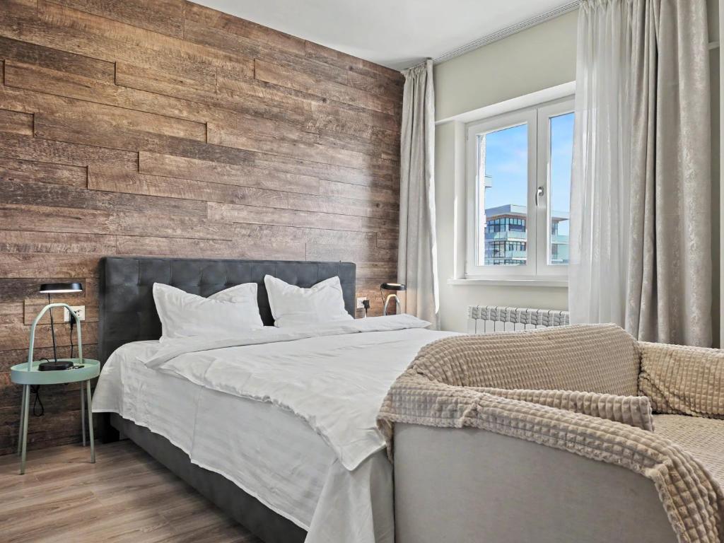 a bedroom with a bed and a wooden wall at Konstanzer 95 - Cozy Studio - Iulius Mall - AC in Iaşi