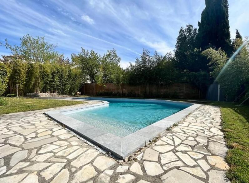 a swimming pool in a yard with a stone patio at Maison familiale dans le var in Brignoles