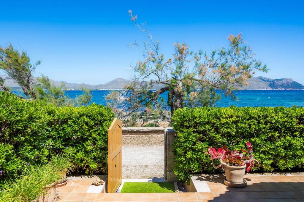 a garden with a wooden door and a view of the water at Can Figó in Alcudia