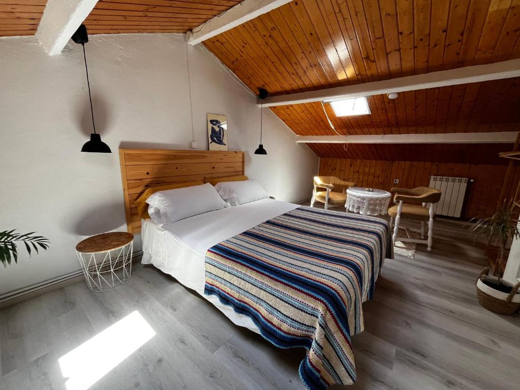 a bedroom with a large bed with a striped blanket at Atico de madera Apartamento en Rinlo, RIBADEO in Ribadeo