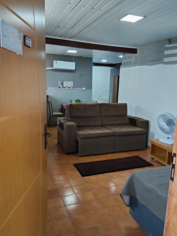 a living room with a couch and a table at Espaçoso para casais in Vila Velha