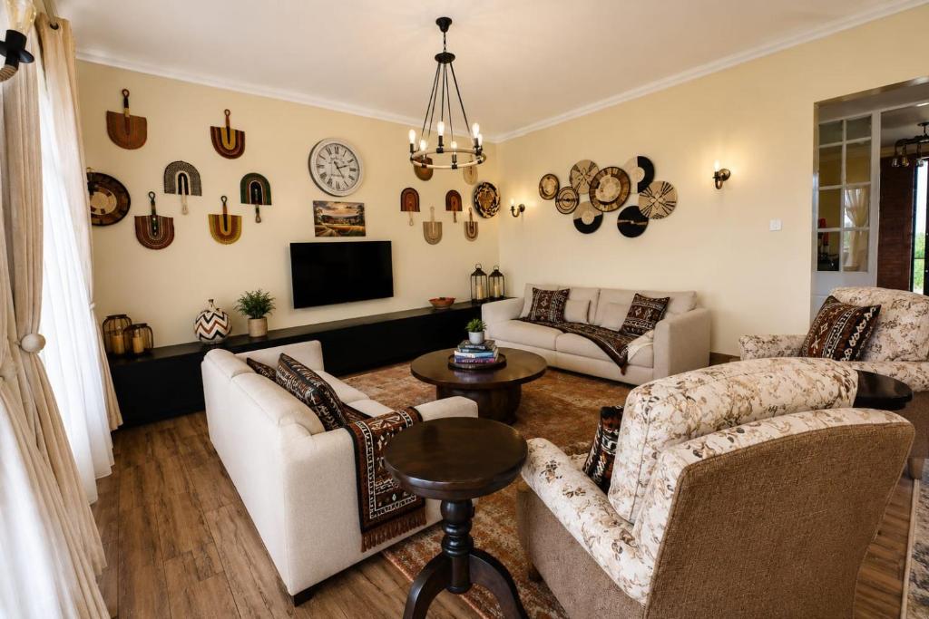 a living room with two couches and a tv at Shamba la Chini in Nairobi
