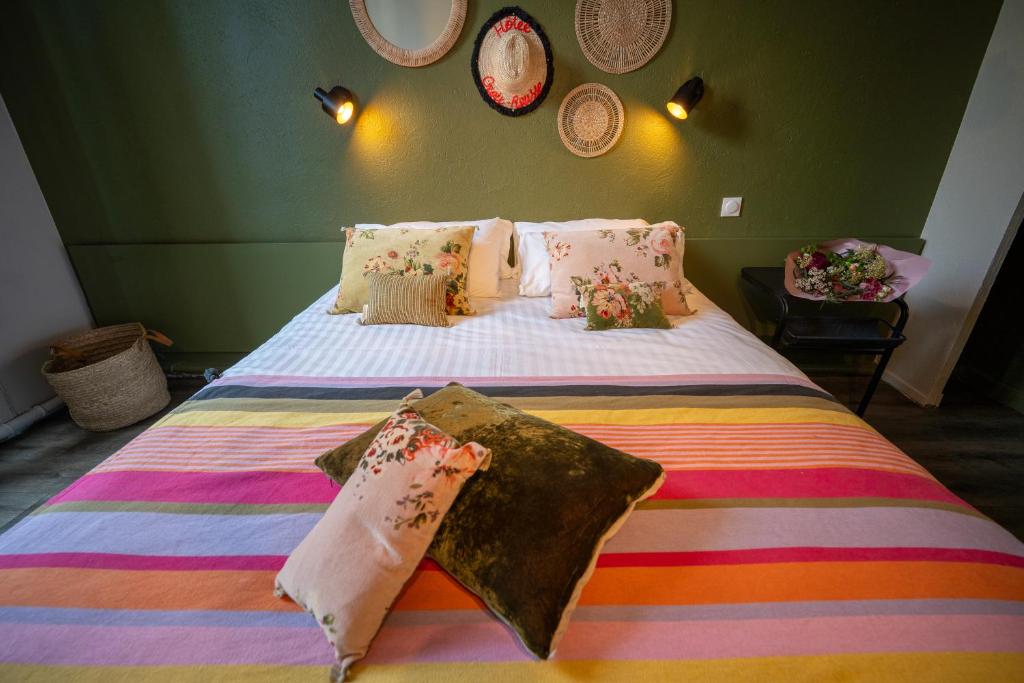 a bedroom with a large bed with colorful sheets and pillows at Hôtel de la Croix-Rousse in Lyon
