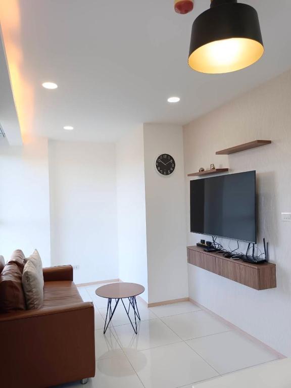 a living room with a couch and a flat screen tv at Modern Condo Infinity Pool Gym Near Beach in Bang Sare