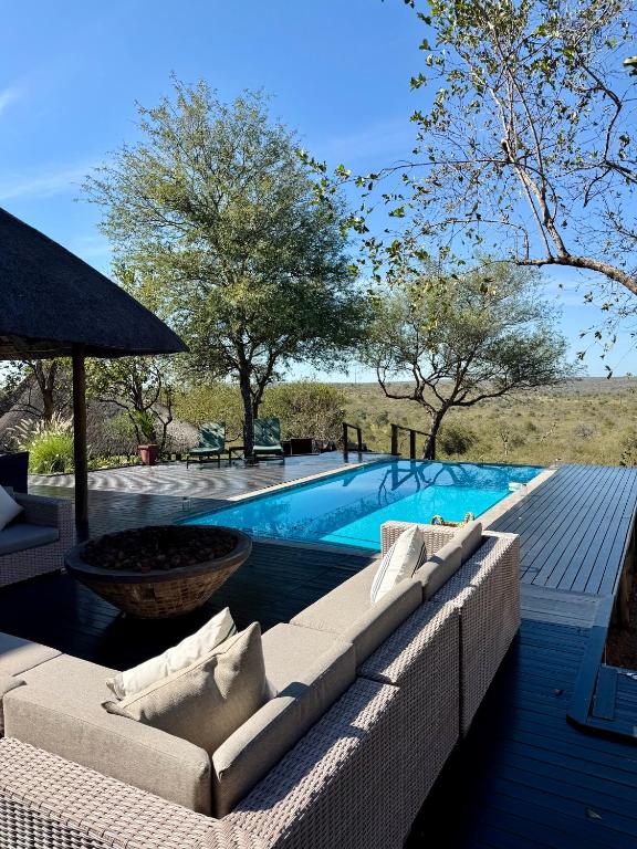 a swimming pool with couches and a swimming pool at Tulani Boutique Lodge - Includes Game drives and Meals in Grietjie Game Reserve