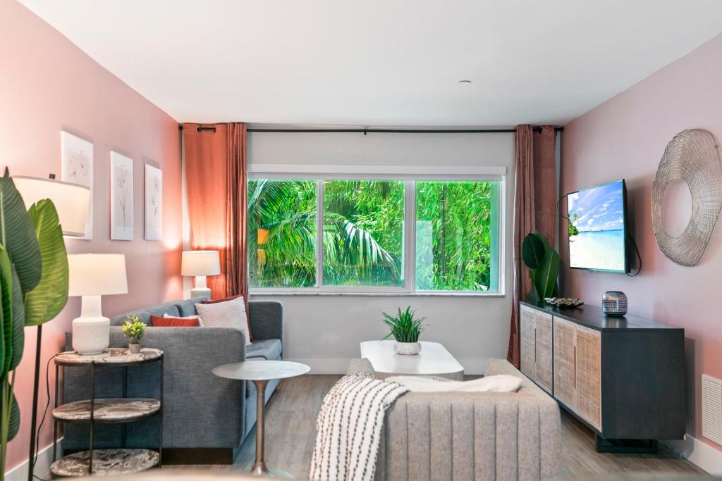 a living room with a couch and a window at King Suite, Private Beach Path, Pool & Hot Tub in Boca Raton
