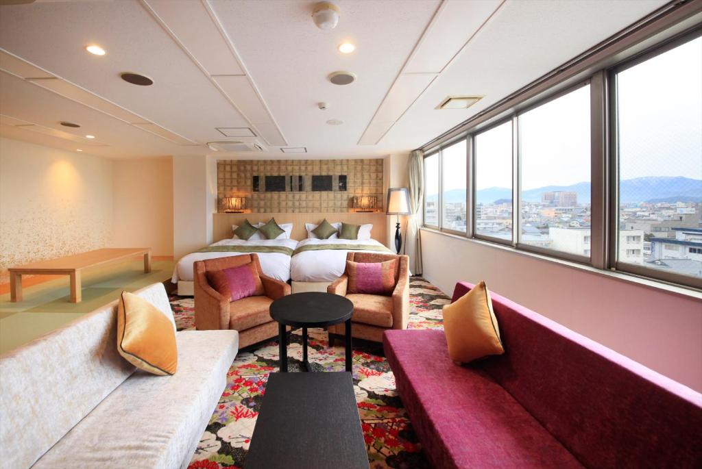 een hotelkamer met een bed en een bank bij Centurion Hotel Villa Suite Fukui Ekimae in Fukui