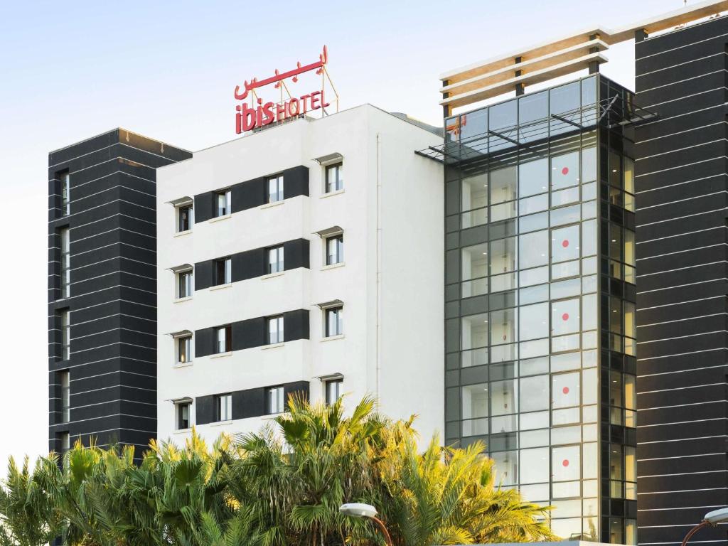 a white building with a sign on top of it at ibis Oran les Falaises in Oran