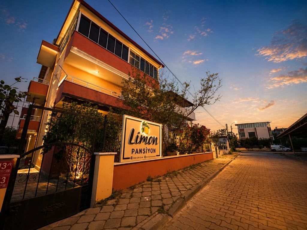 a building with a sign on the side of a street at Limon Pansiyon Burhaniye in Burhaniye