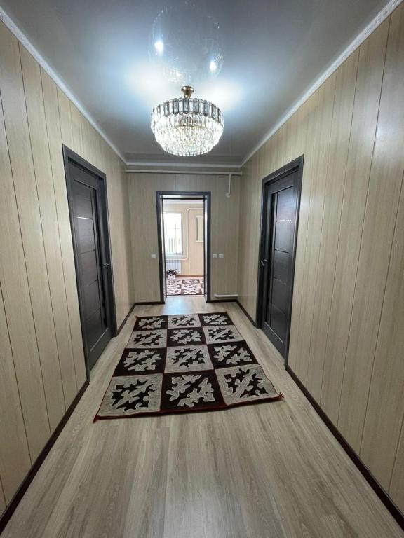 a hallway with a chandelier and a room with a rug at Sun Garden Guest House in Ak-Say