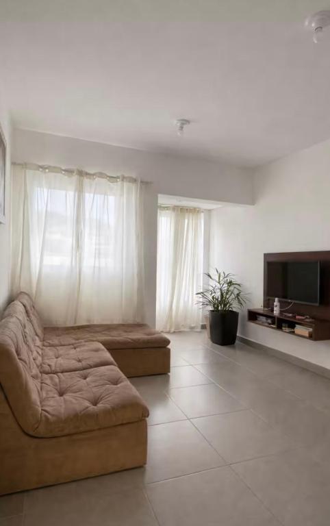 a living room with a couch and a flat screen tv at Sobrado em volta do lago in Lindóia