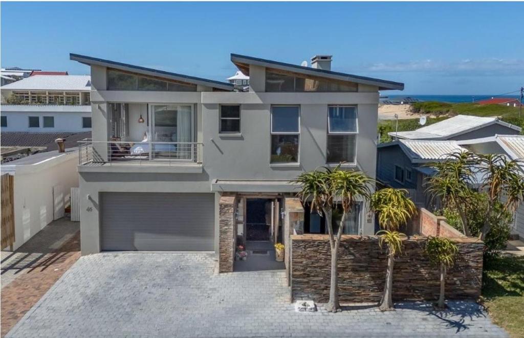 a large white house with palm trees in front of it at Jubilee in Buffelsbaai