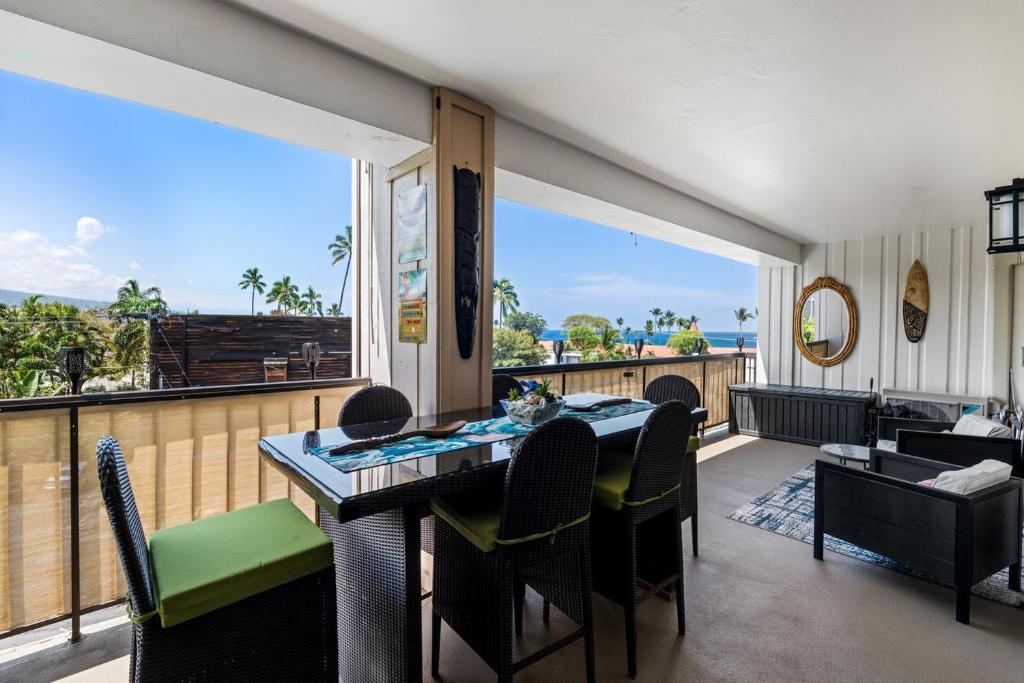 a dining room with a table and chairs and a large window at Kona Plaza#409 in Kailua-Kona