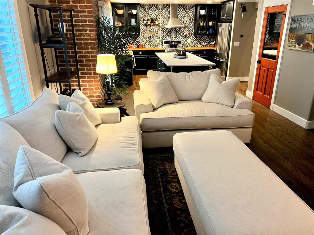 a living room with white couches and a kitchen at BoCo Bungalow in Superior