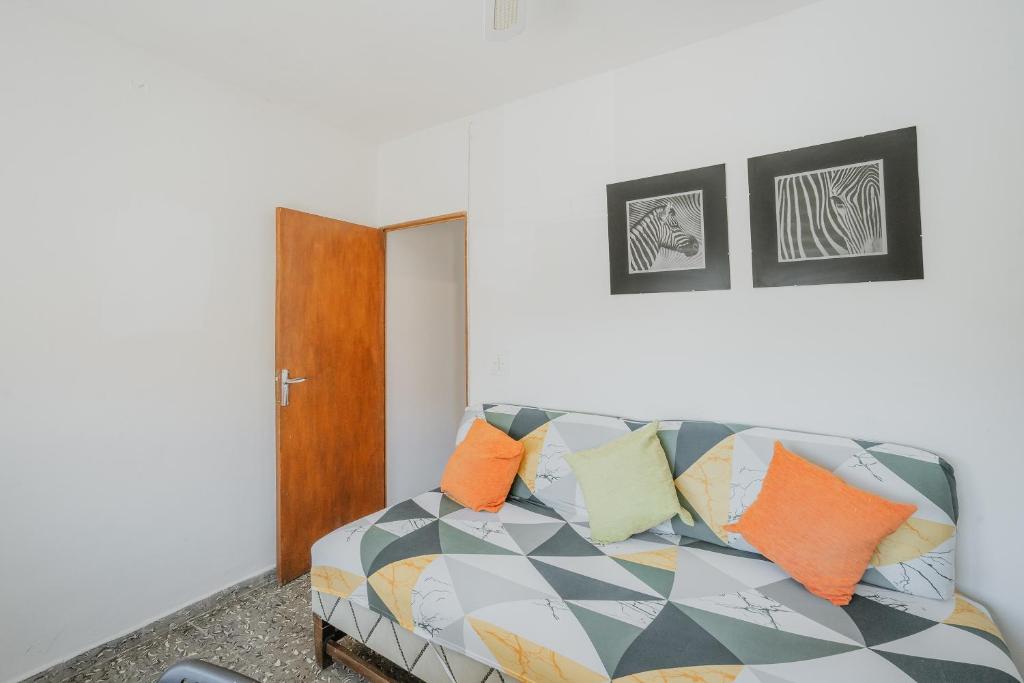 a living room with a couch with colorful pillows at Pisito de Pueblo I I in Navaluenga