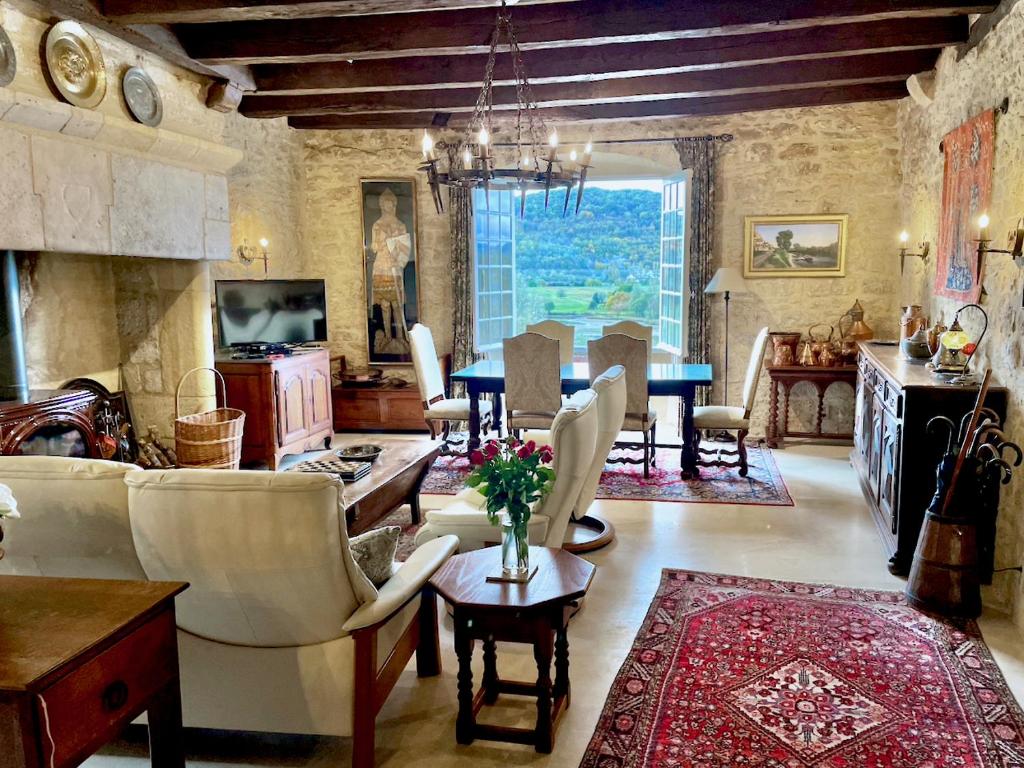 a living room with a table and a dining room at Villa Mont Joie in Beynac-et-Cazenac