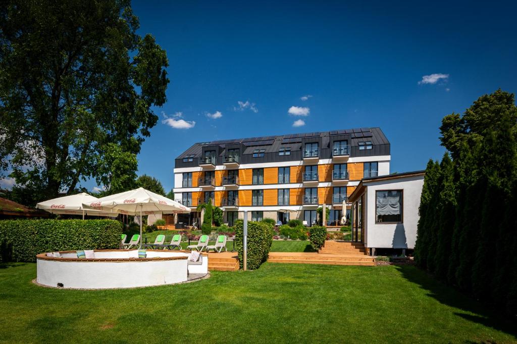 a large building with a lawn in front of it at Hotel Uniejów in Uniejow
