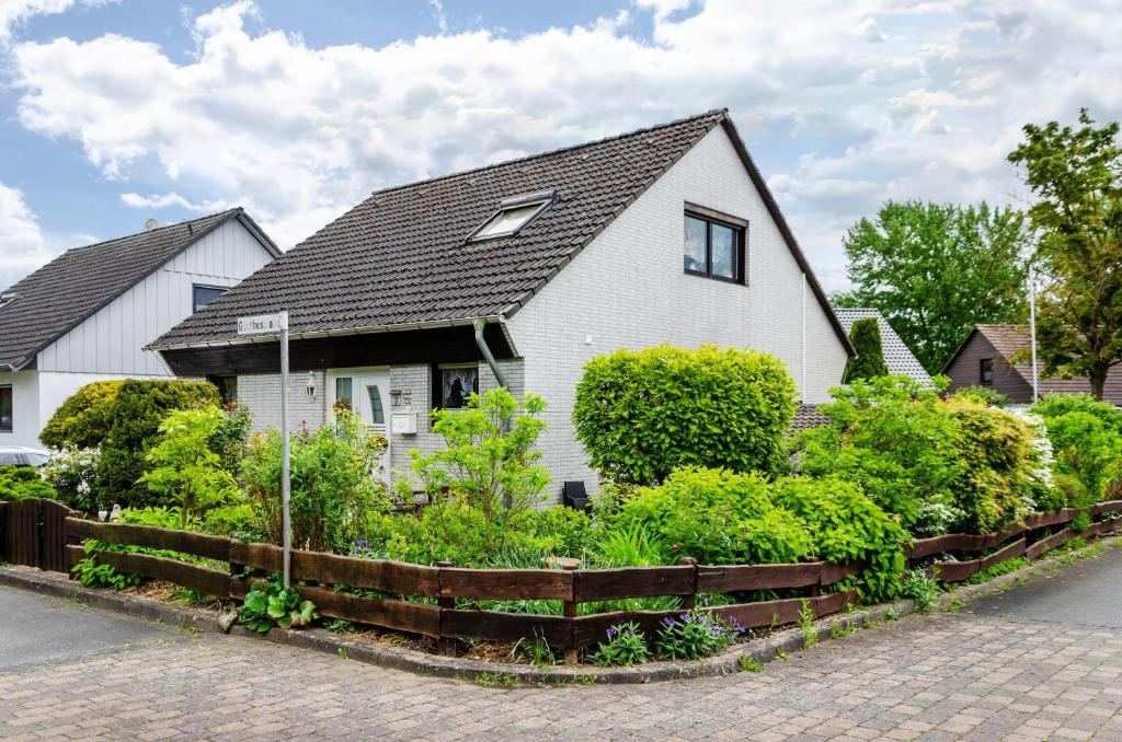 a white house with a garden in front of it at Ferienwohnung Zum Leiselsee in Baunatal