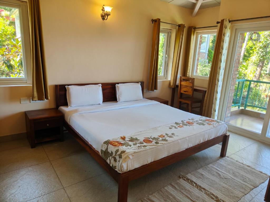 a bedroom with a bed in a room with windows at Azalea in Jajal