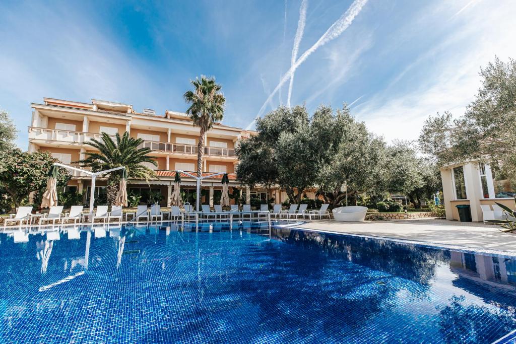 a large swimming pool in front of a hotel at Resort Trcol in Novalja