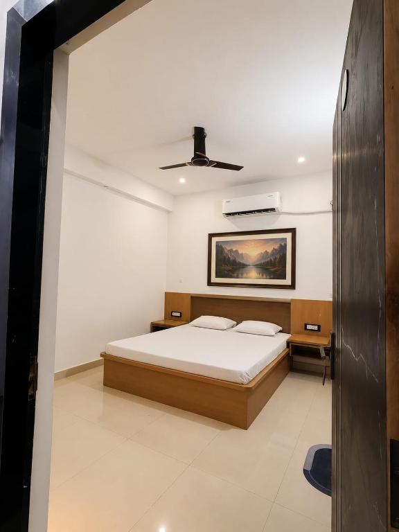 a bedroom with a bed and a ceiling fan at Hotel SunFort in Rājgīr