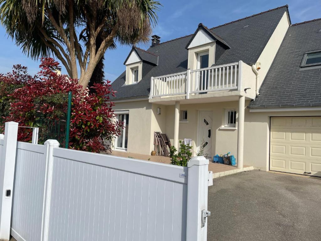 a white fence in front of a house at Maison avec balcon in Saint-Hilaire-Petitville