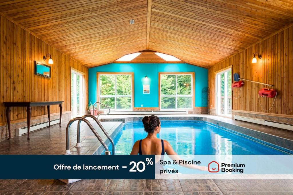 a woman standing in a swimming pool in a house at La Tour Boisée with Private Spa & Pool, Pool Table in Sainte Béatrix