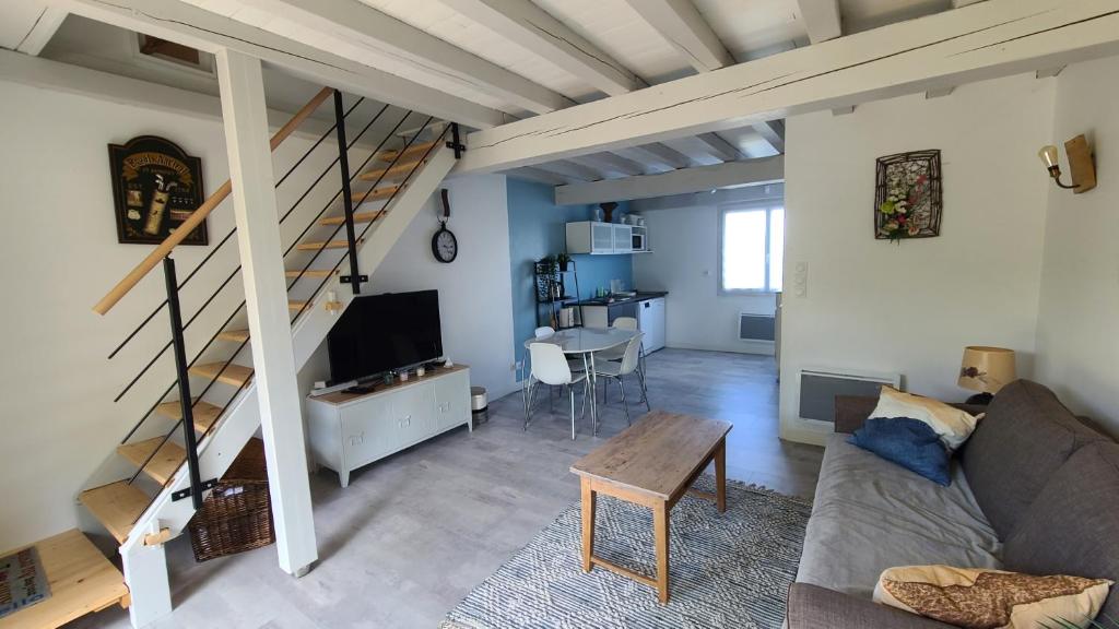 a living room with a couch and a staircase at L'annexe des Iris in Chaponost