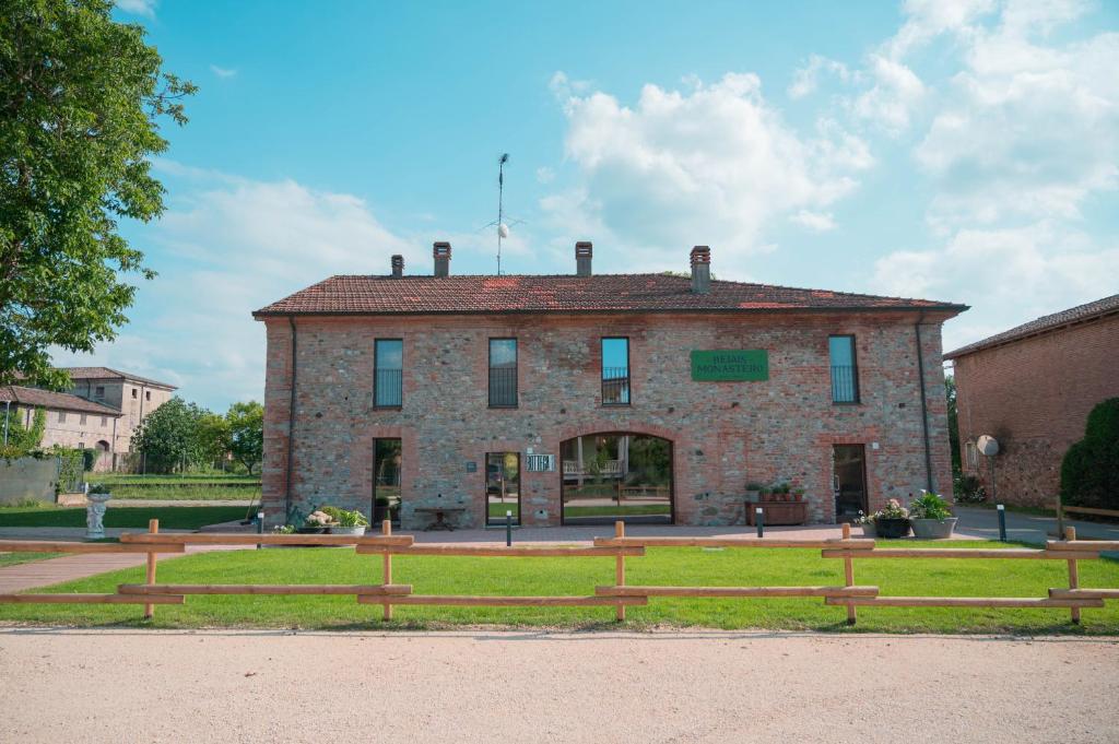 ein altes Backsteingebäude mit einer Bank davor in der Unterkunft Relais Monastero in Podenzano