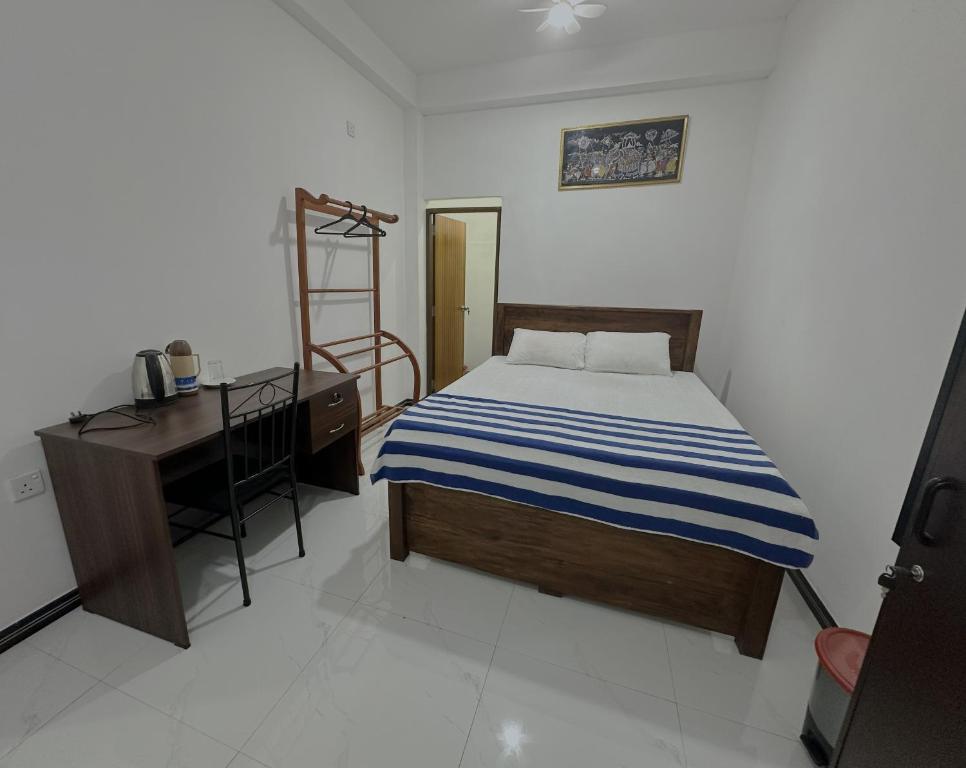 a bedroom with a bed and a desk and a bed sidx sidx sidx at White House Galaha in Galaha Town
