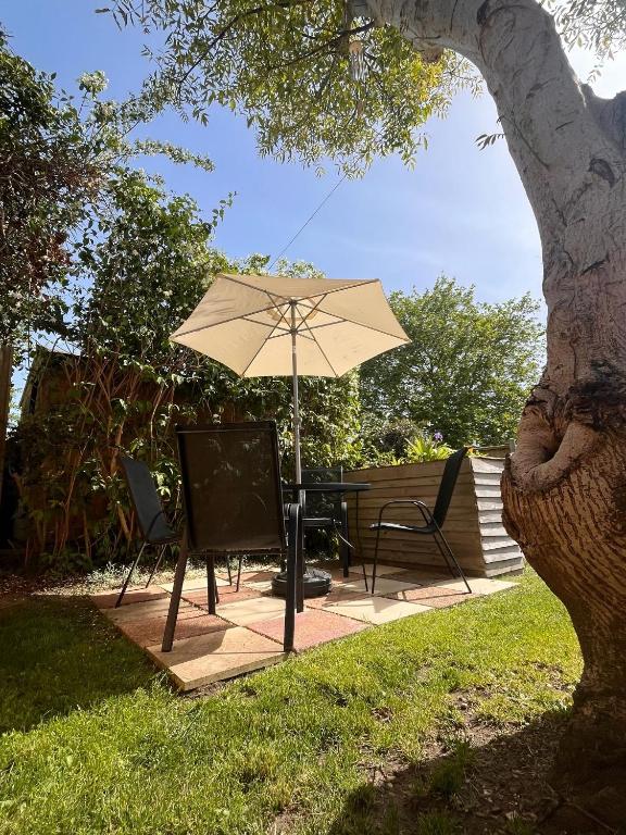 a patio with a table and an umbrella and chairs at Apartment 288 in Lower Swanwick