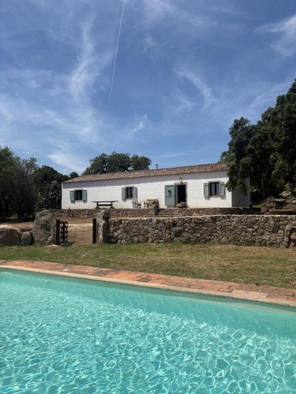 a house and a swimming pool in front of a building at Antico Stazzo Gallurese in Luogosanto