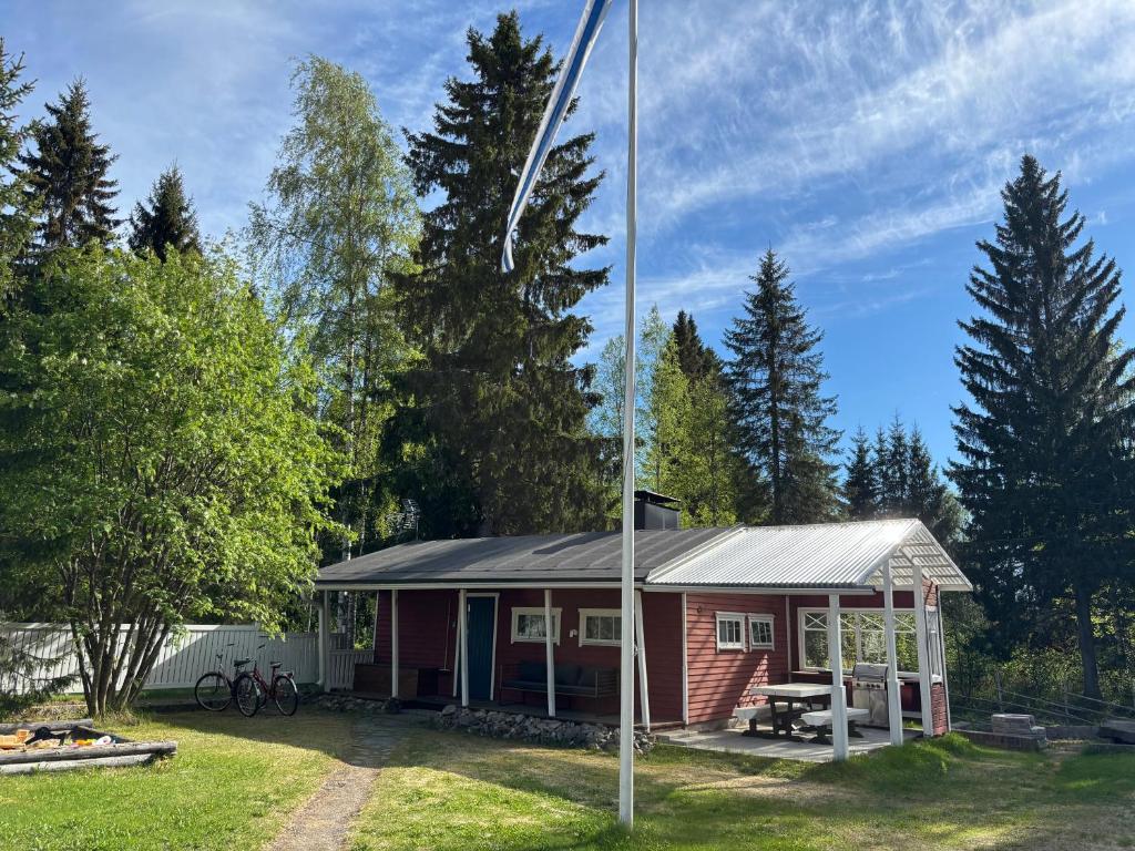 a small house with a flag pole in the yard at Guest cabin, Haukipudas, sauna and free parking in Haukipudas