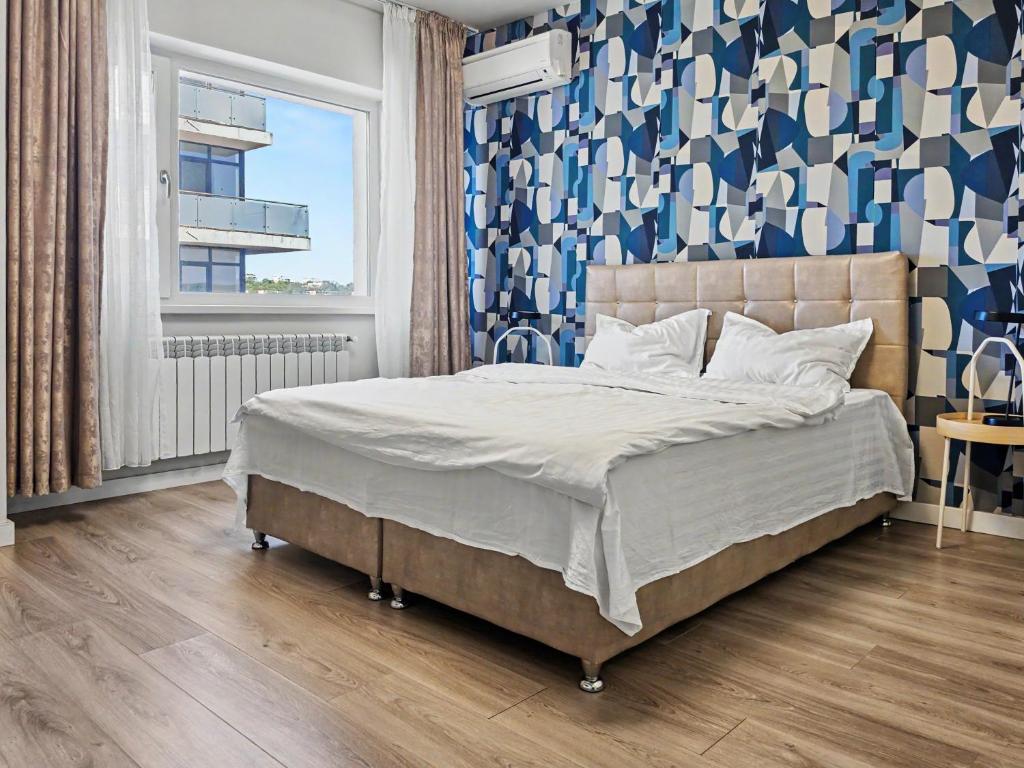 a bedroom with a bed with a blue and white wall at Konstanzer 44 - Urban Studio - Iulius Mall - AC in Iaşi