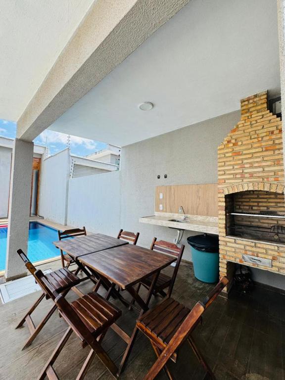 a dining room with a table and chairs and a fireplace at Casa Perfeita Paracuru in Paracuru