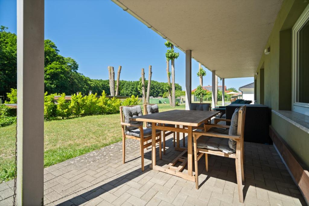 a wooden table and chairs on a patio at Ferienhaus Träumerei am Plauer See in Alt Schwerin