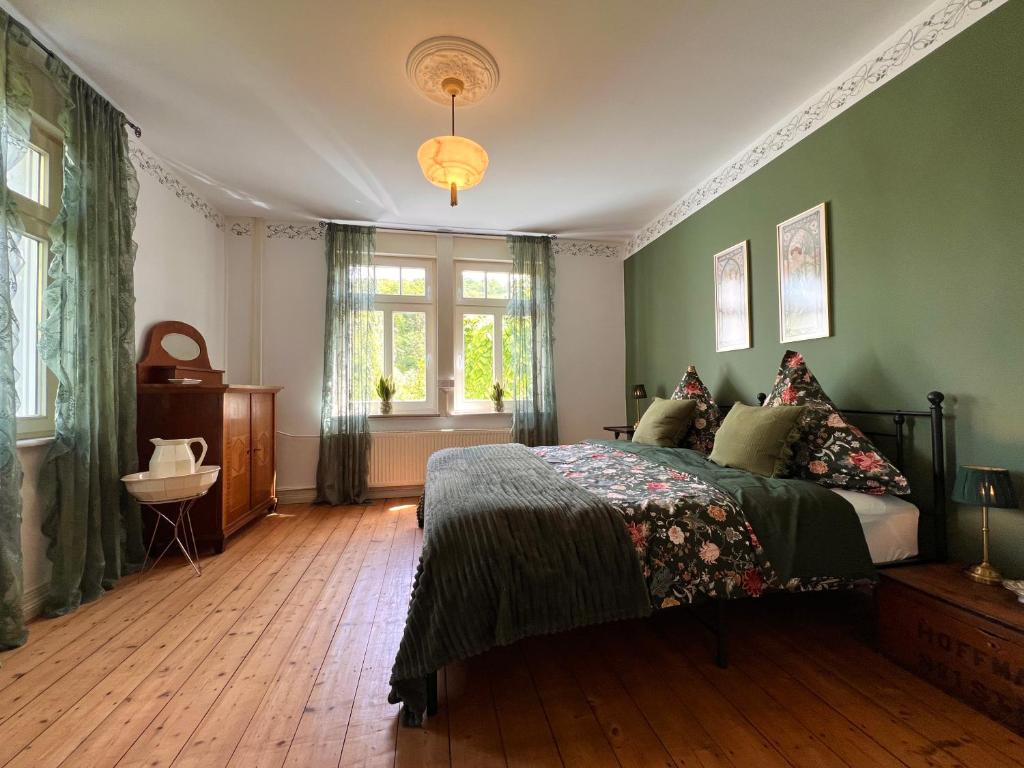 a green bedroom with a bed and a window at Villa Belle in Freudenberg