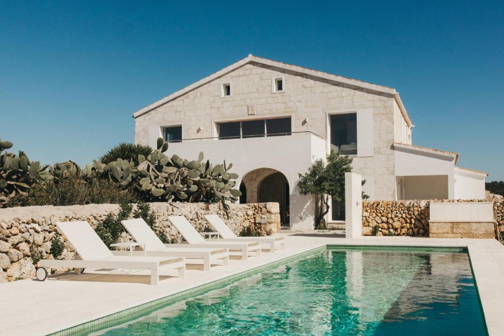 a villa with a swimming pool in front of a house at SON MARTORELL by BookMenorcaVillas Unique country house in Mahón
