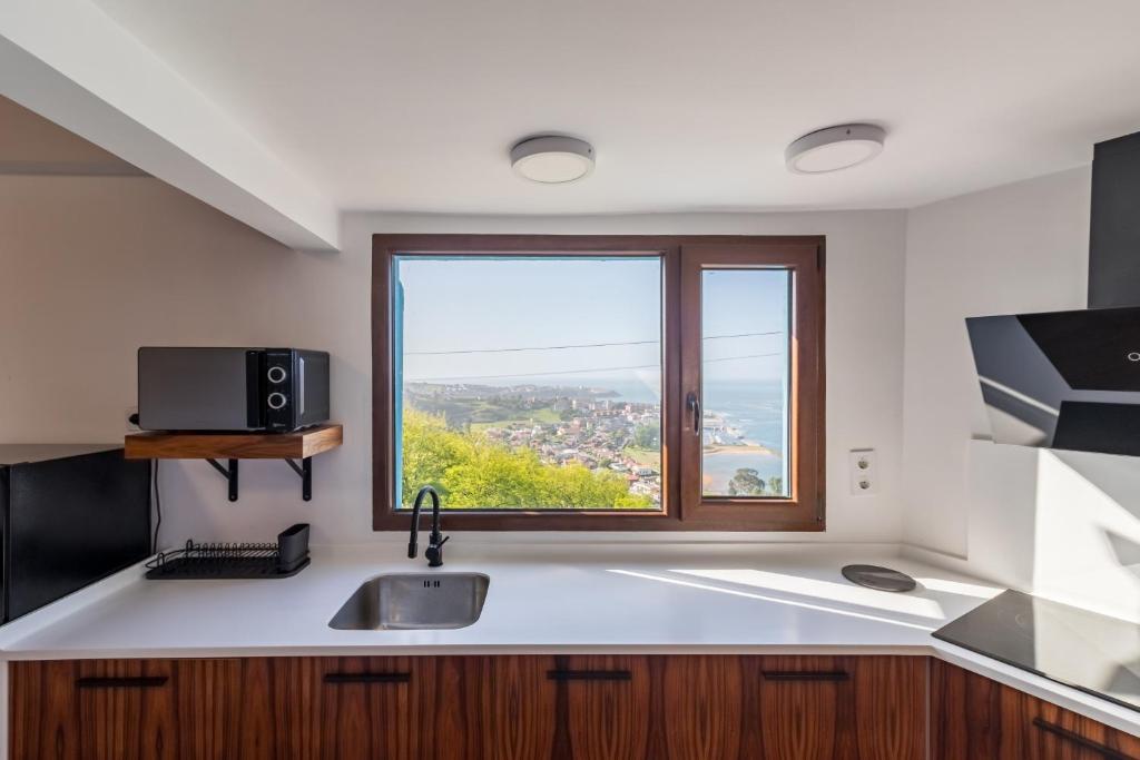 a kitchen with a sink and a window at El Rincón de Denver in Suances
