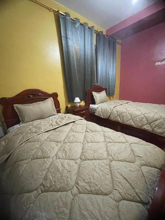 a bedroom with two beds and a window at MRIRT Home N4 in Jemaa de Mrirt