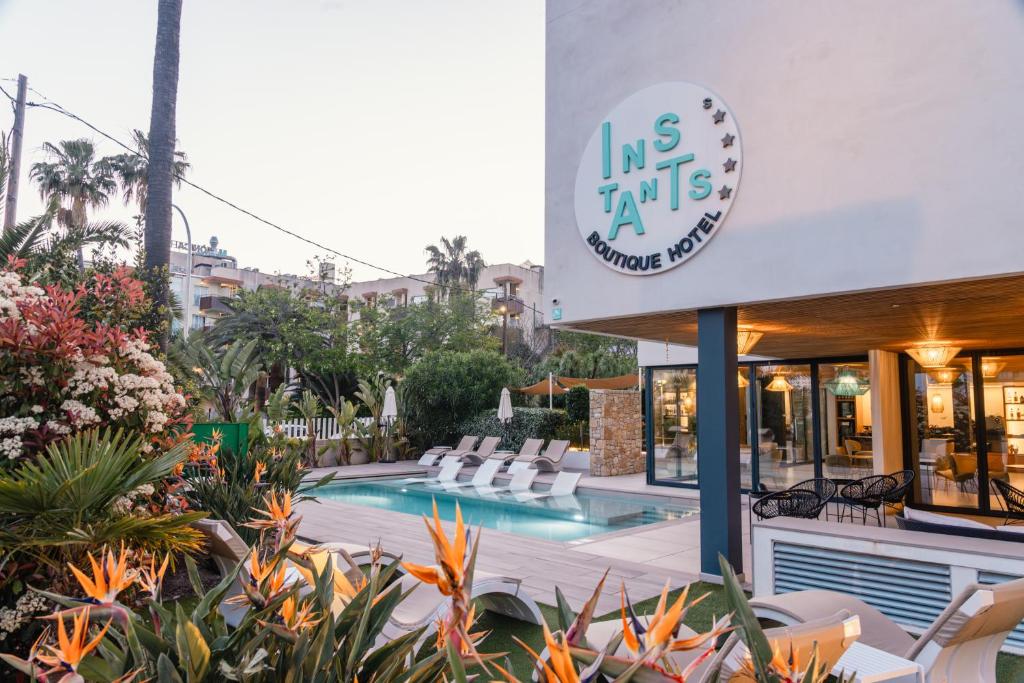 a hotel with a swimming pool in front of a building at Instants Boutique Hotel in Cambrils