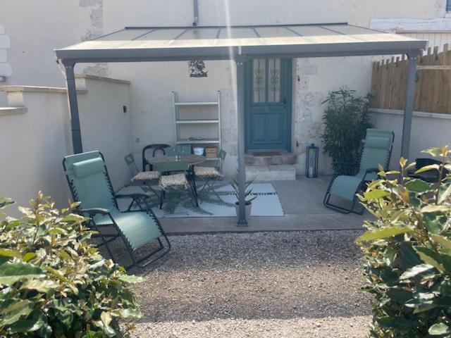 a patio with four chairs and a blue door at Chat-Douillet in Veuzain-sur-Loire
