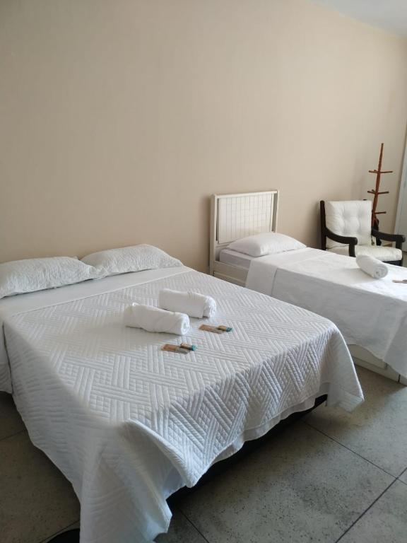 two beds in a room with towels on them at Loft Campinho 2 in Estação Inhoaíba