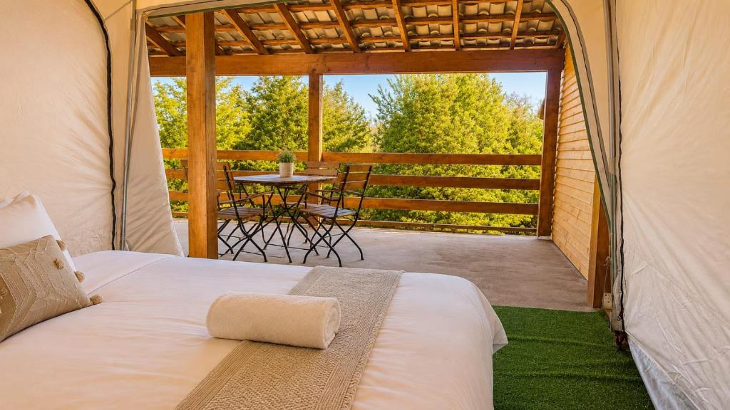 a bed in a tent with a table on a patio at Marina Park Camping in Vama Veche