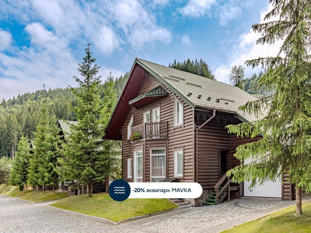 a log home with a sign in front of it at Bukovel Hotel in Bukovel