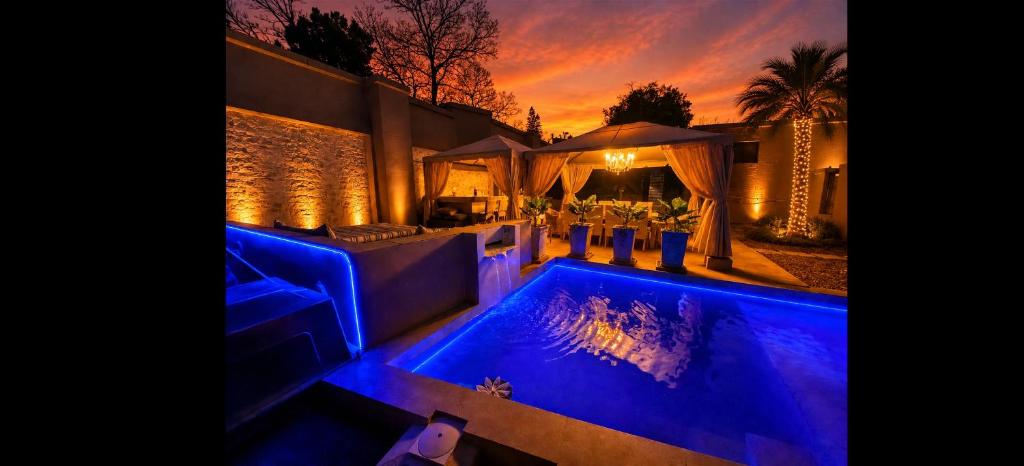 a house with a swimming pool with blue lighting at Bryanston Palms Accommodation in Johannesburg