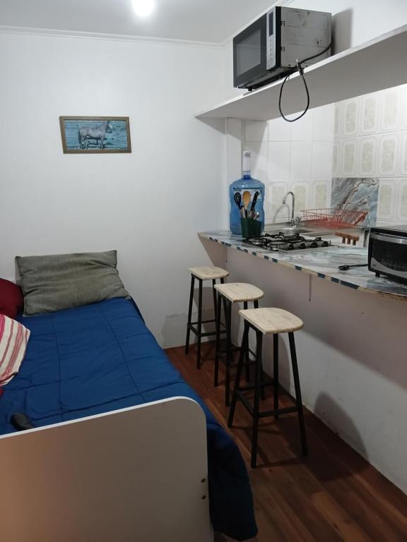a small bedroom with a bed and a kitchen at Cabañas Laguna Verde Valparaiso in Laguna Verde