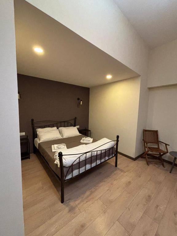 a bedroom with a bed and a chair at Dvali in Tbilisi City