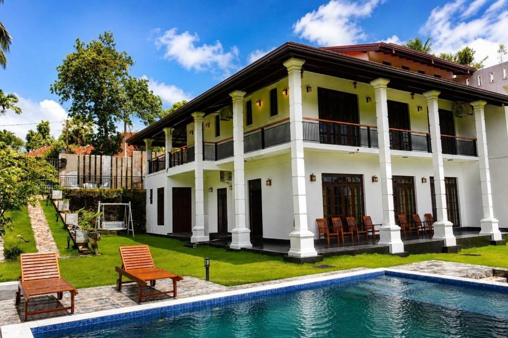 a house with a swimming pool in front of it at Emerald Edge Villa in Minuwangoda